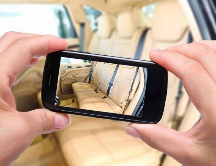 Hands taking photo car interior with smartphone