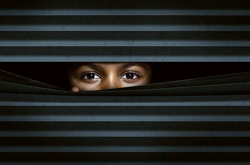 Tips to securing your webcam and protecting yourself from prying eyes by a child peeking out from behind a curtain.