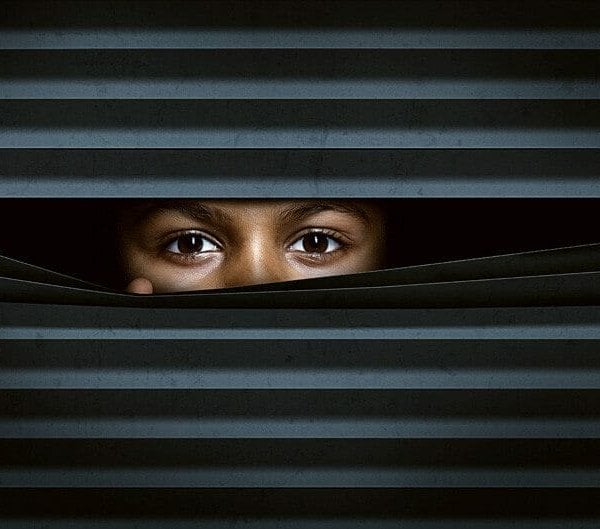 Tips to securing your webcam and protecting yourself from prying eyes by a child peeking out from behind a curtain.