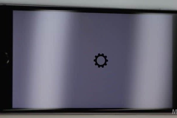 A black iPhone with a gear icon on the screen in a leaked video.