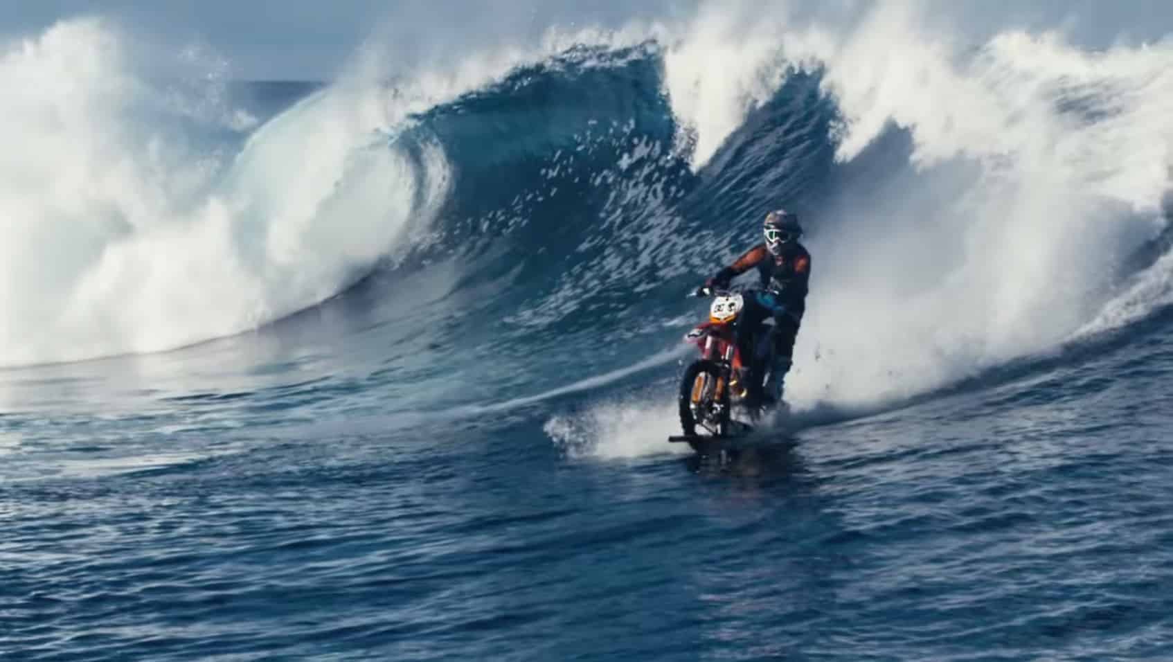A man RIDEs a motorcycle through a large wave in Robbie Maddison's "Pipe Dream.