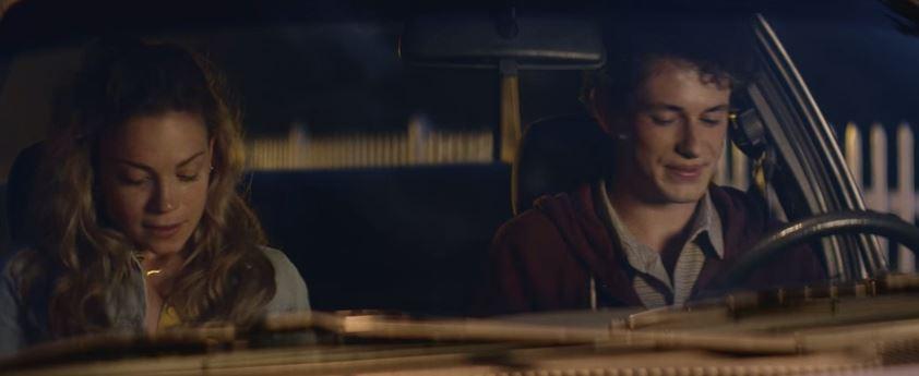 A couple in a car exchanging happy glances.