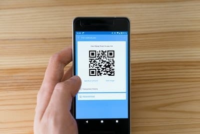 An individual securely accessing BDO Online Banking via a smartphone and QR code.
