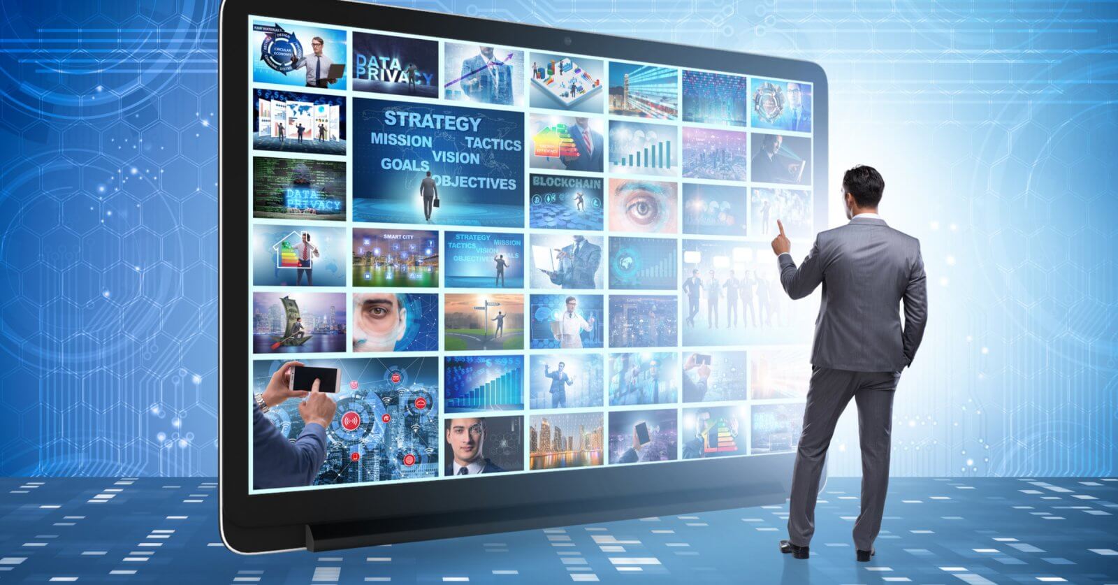 A person in a suit interacts with a large digital display showcasing various futuristic images and graphs reminiscent of the advanced technology seen in popular Pinoy movies on streaming platforms