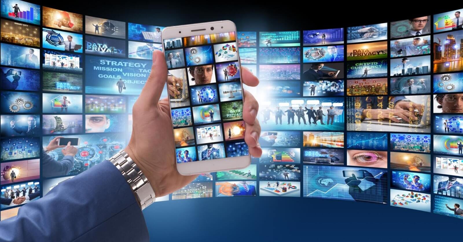A hand holds a smartphone displaying multiple screens surrounded by a curved wall of digital images and videos from Pinoy Movie Streaming