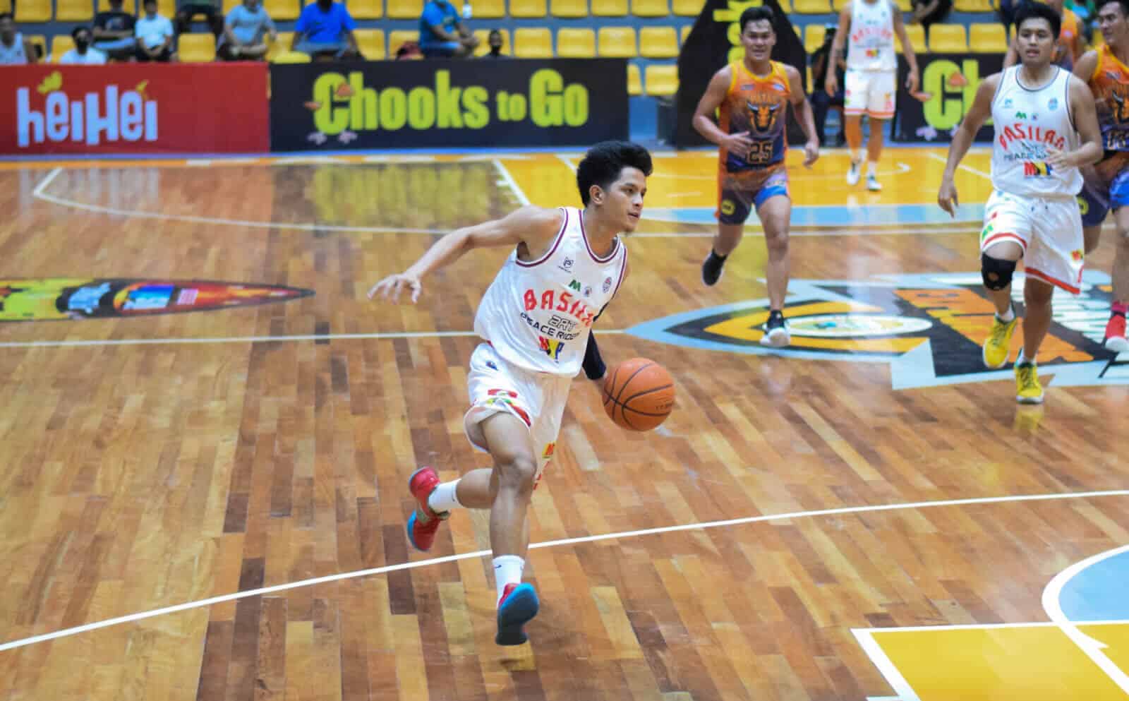 A basketball player dribbling the ball on a hardwood floor during an upset win over Kapatagan in VisMin Cup.