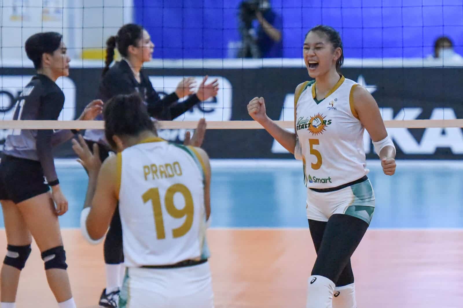 A group of female volleyball players, including top blocker Mika Reyes, celebrating a goal as PLDT caps off their recruitment spree.