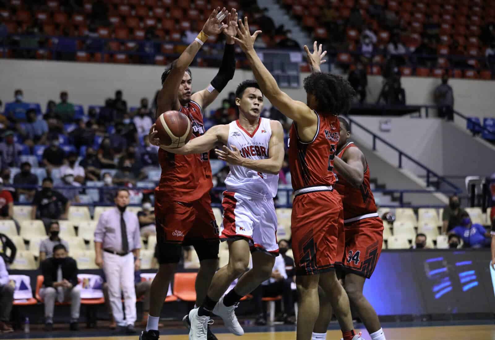 A group of basketball players blocking the ball during a win by Barangay Ginebra.