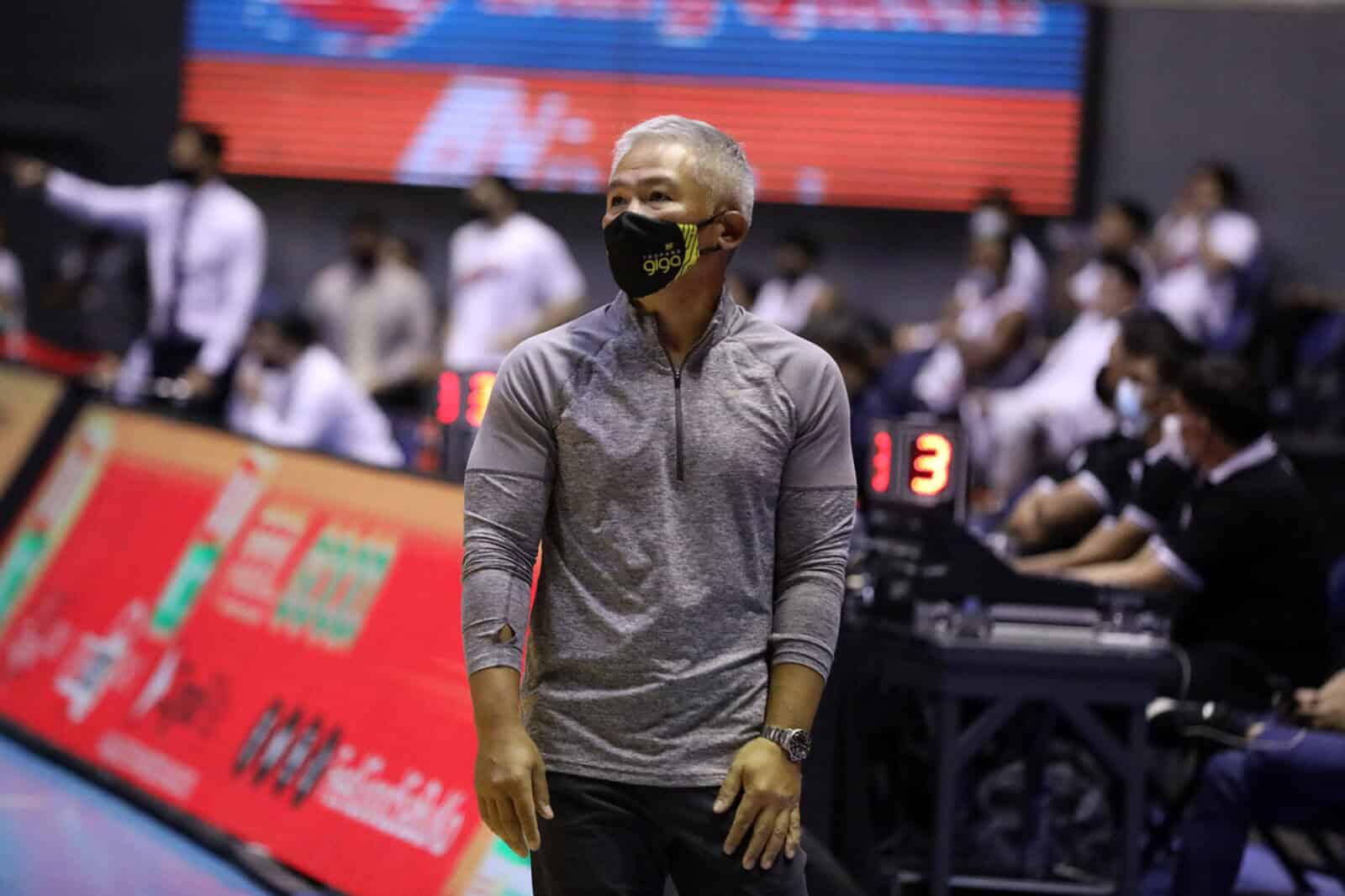 A man wearing a face mask joins Chot Reyes on a basketball court.