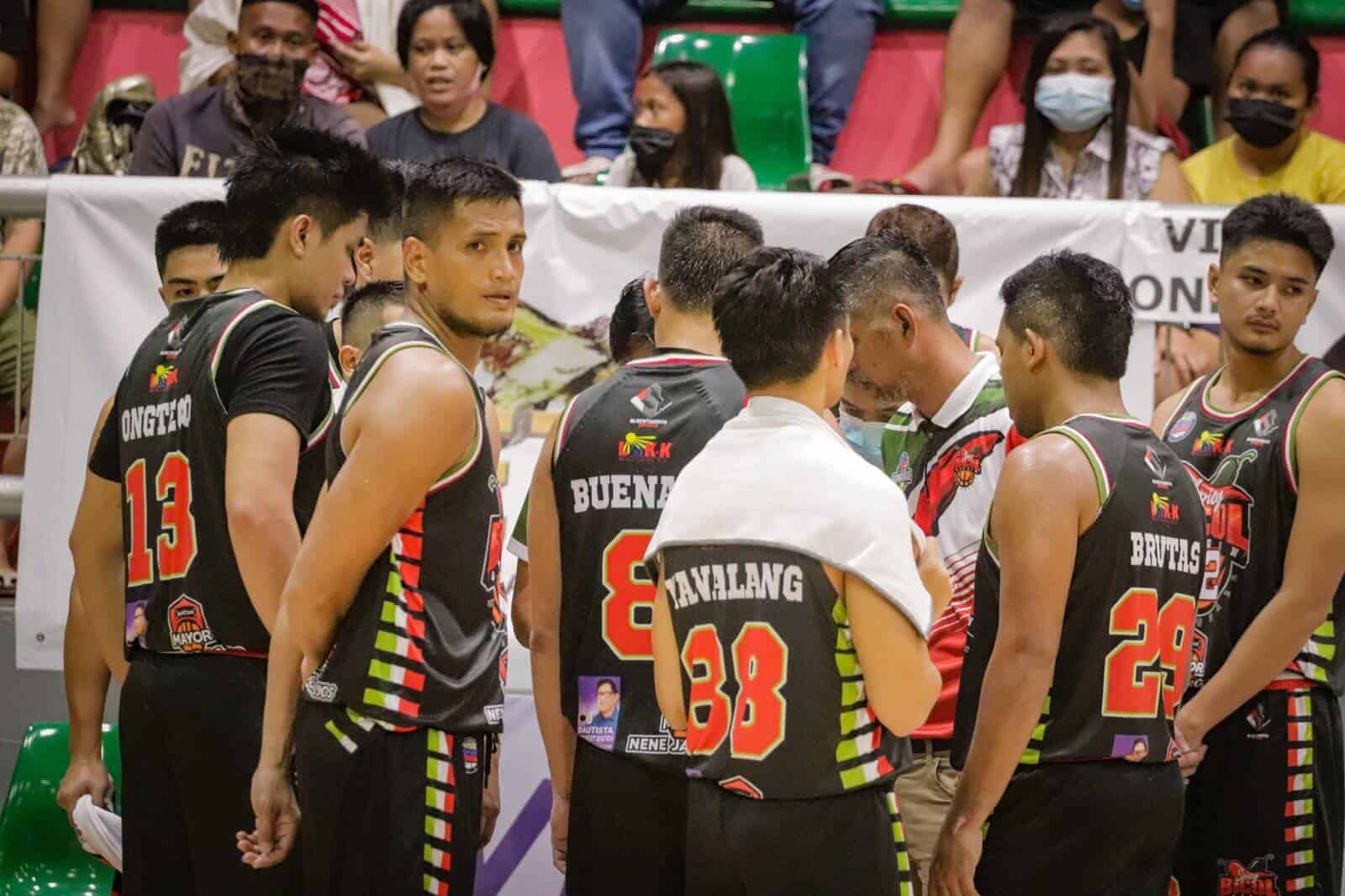 A group of basketball players huddle together in front of a crowd at the Pearl of the Orient Cup.