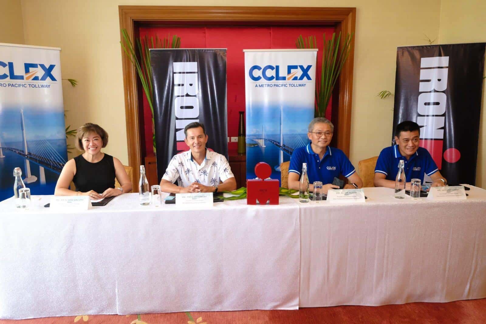 A group of Longest Bridge in the Country triathletes sitting at a table with banners.