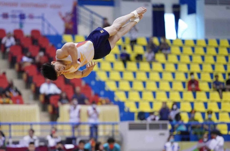 A male gymnast from the Philippines competes in the air, earning gold medals at the Hanoi SEA Games.