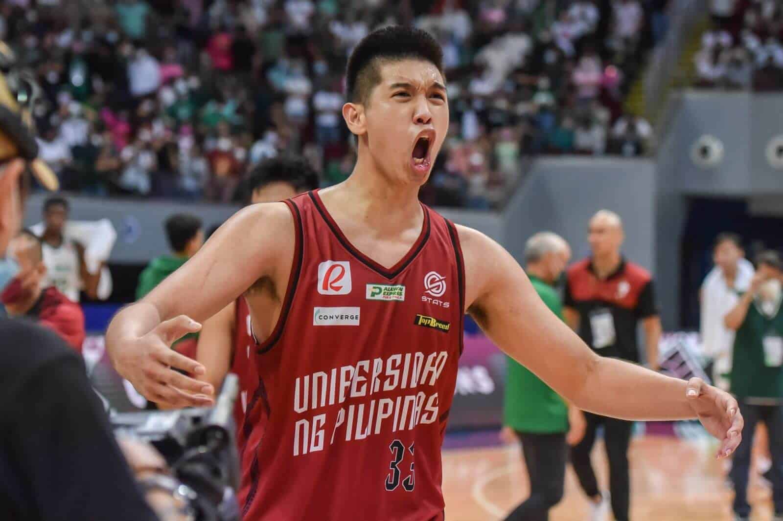 A basketball player from University of the Philippines celebrates on the court after beating La Salle and securing a UAAP finals ticket.