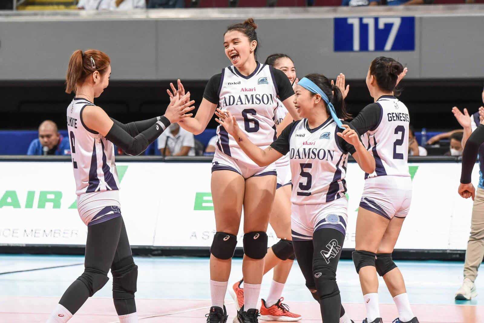 A group of female volleyball players celebrating their first win at the expense of Ateneo de Manila University.