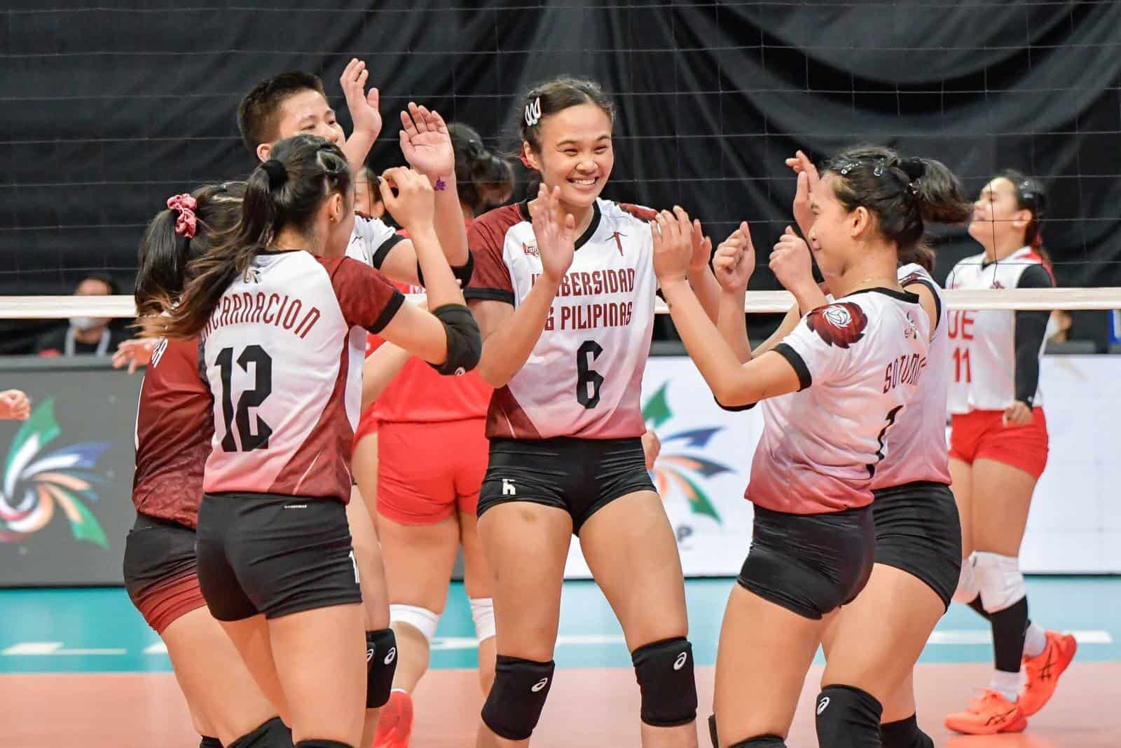 A group of female volleyball players high fiving each other during UP's UAAP Season 84 campaign.