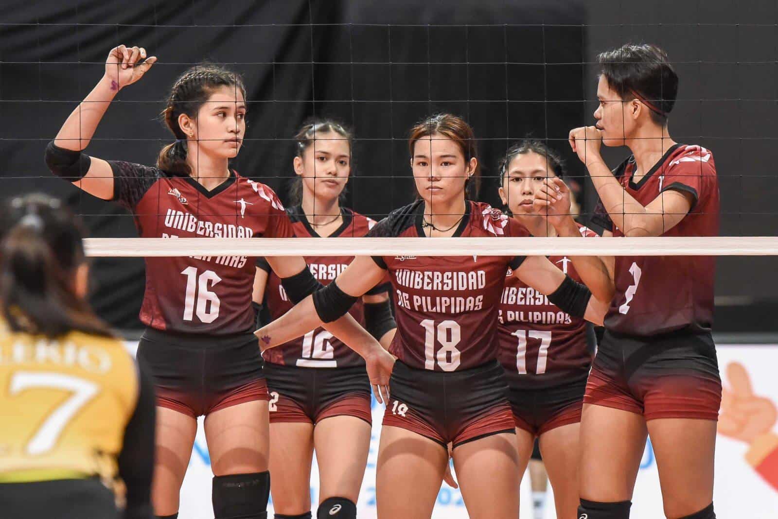 A group of female UP Fighting Maroons volleyball players are standing on a court.