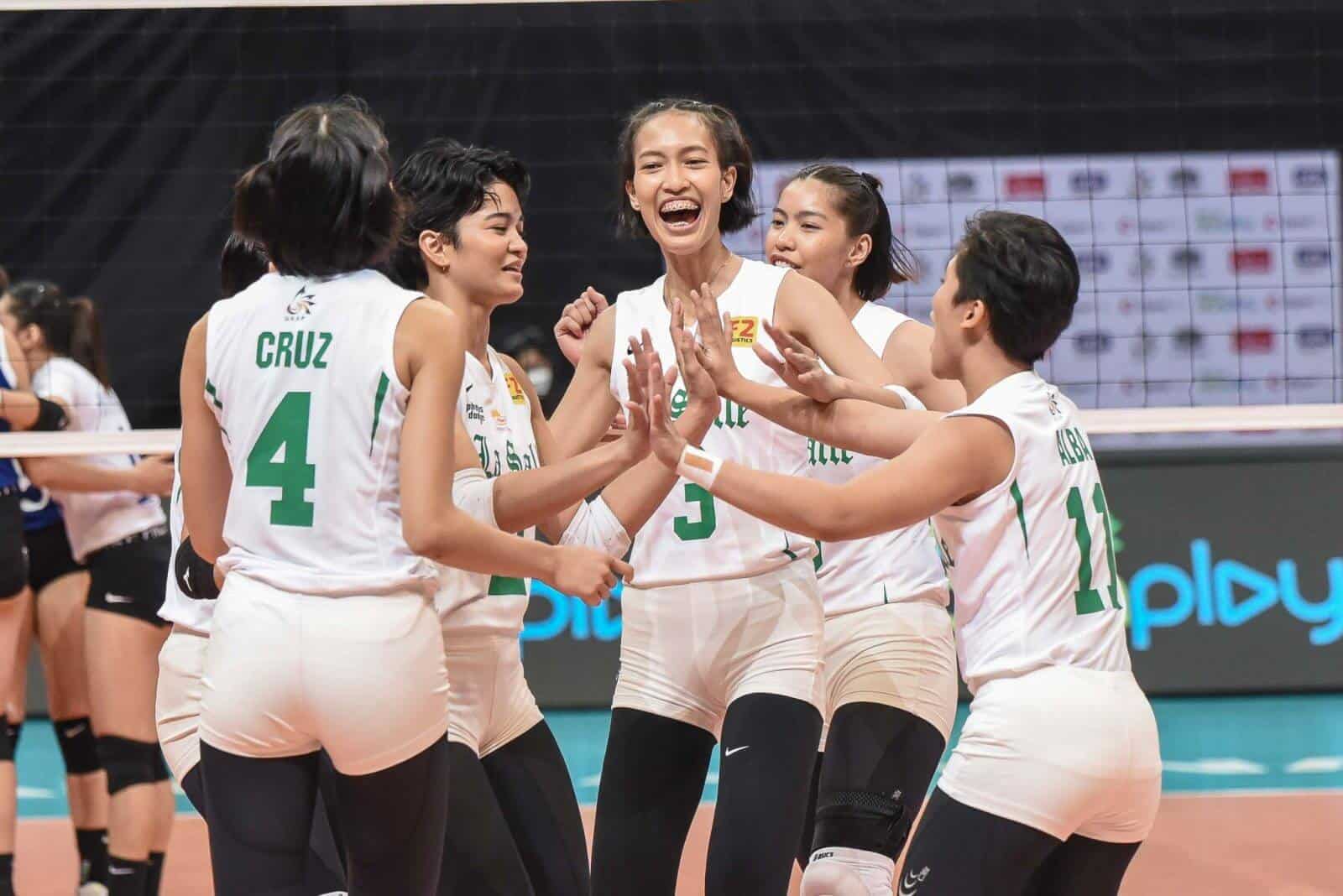 A group of female volleyball players celebrating after La Salle boots out Ateneo to claim last finals seat in the UAAP women's volleyball finals.