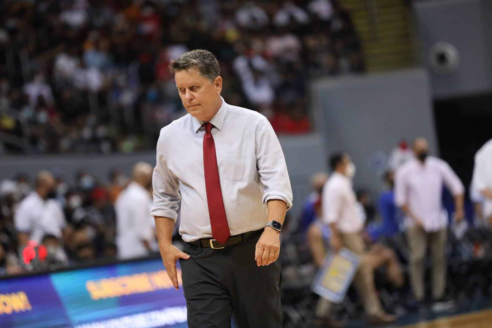Tim Cone walking on a basketball court.