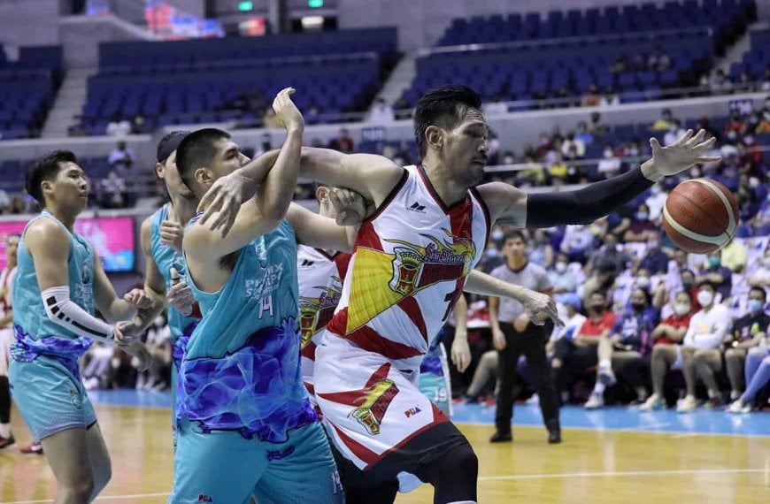 A San Miguel Beermen basketball player is striving to score in a game against Phoenix.
