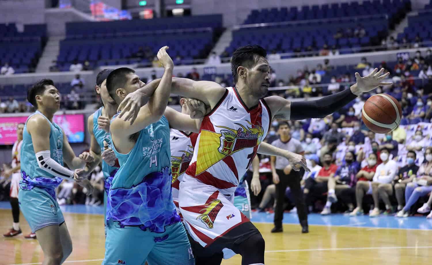A San Miguel Beermen basketball player is striving to score in a game against Phoenix.