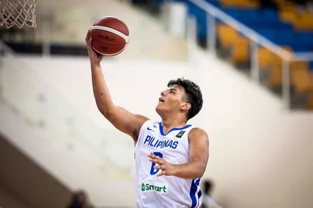 A young man in a white uniform shoots a basketball, leading Gilas Youth to the quarterfinals after routing Kazakhstan.