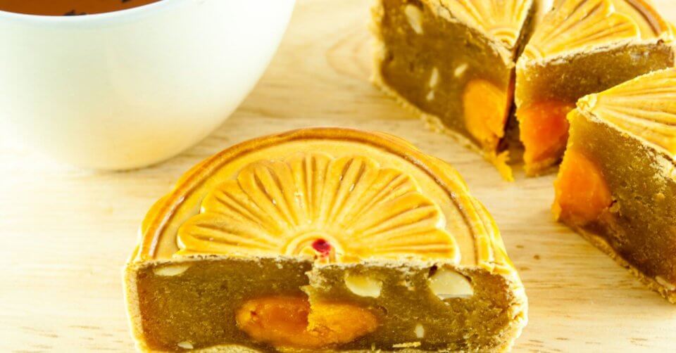 a cup of tea next to a piece of cake enjoyed during the mid autumn festival.