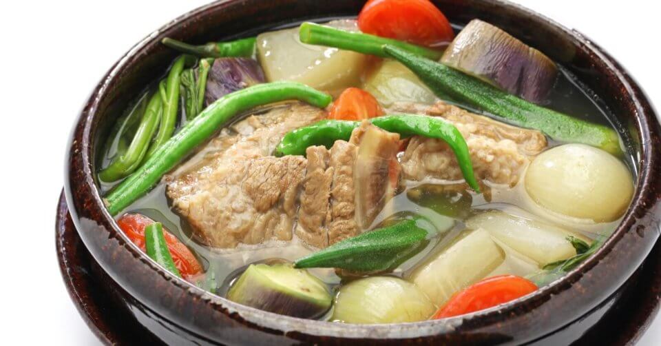 a bowl of soup with meat and vegetables in one of the 48 best restaurants in manila.