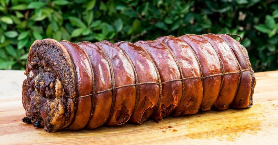a delicious ham is sitting on top of a wooden cutting board.