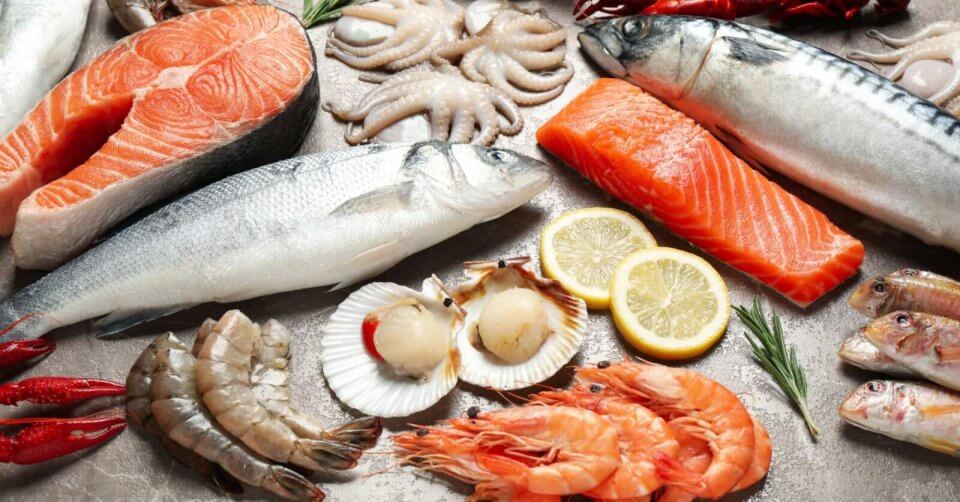 a variety of fish and seafood from the philippines on a wooden table.