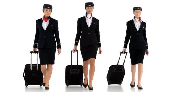 A group of Philippines airline attendants with luggage.