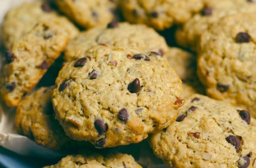 A close-up image of freshly baked chocolate chip cookies from one of Metro Manila's best cookie places, with golden edges and visible chocolate chunks, arranged on a plate lined with parchment paper.