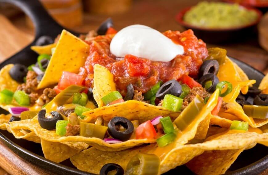 Colorful ingredients are arranged on a bed of crispy tortilla chips in a cast iron skillet at one of Bonifacio Global City's best restaurants.