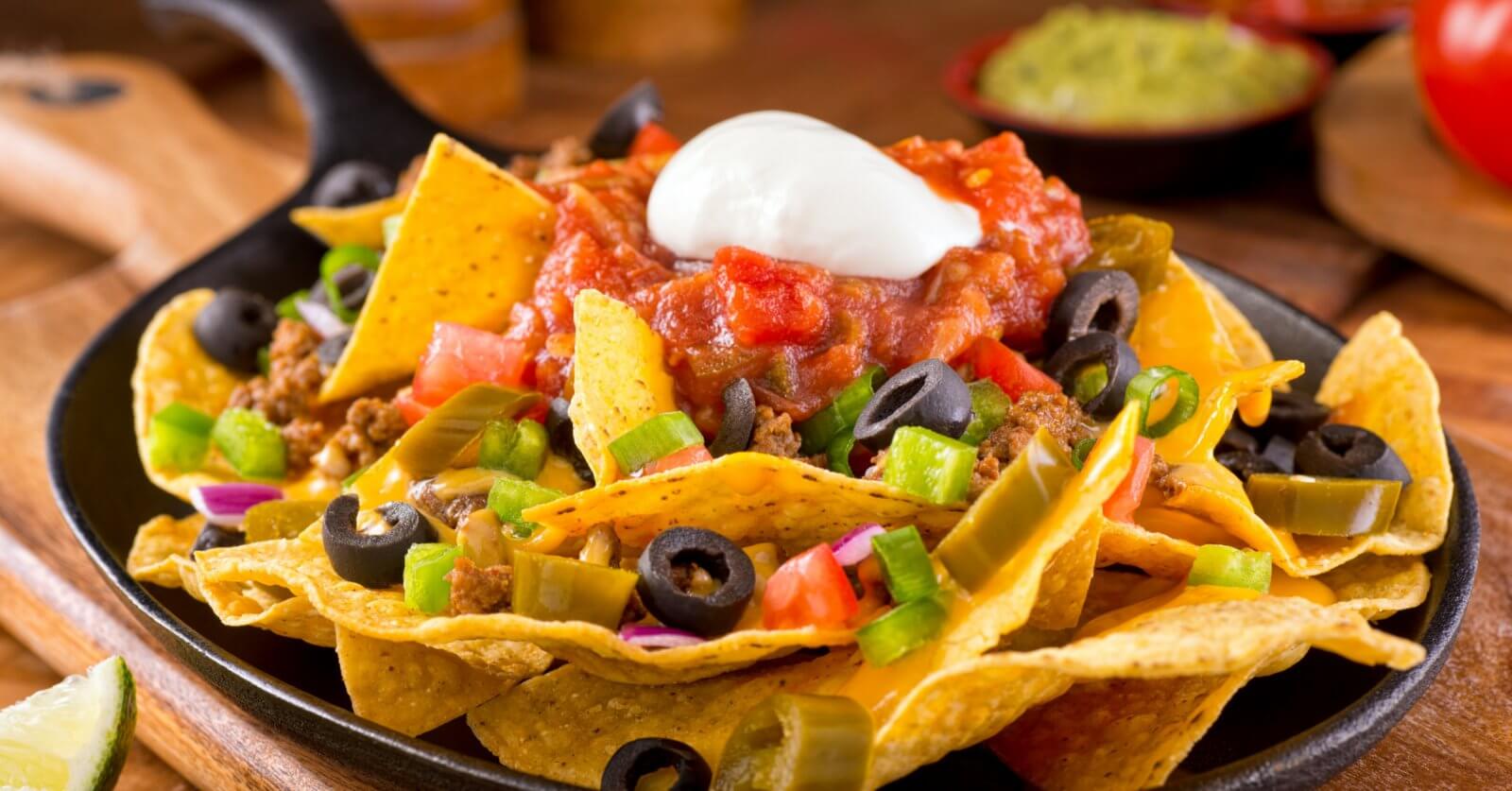 Colorful ingredients are arranged on a bed of crispy tortilla chips in a cast iron skillet at one of Bonifacio Global City's best restaurants.