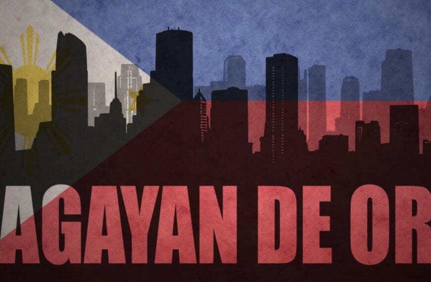 A stylized image of a city skyline with silhouettes of tall buildings. The background features the Philippine flag, blending into the skyline with its blue, red, white, and yellow colors and details. "CAGAYAN DE ORO," renowned for its tourist attractions, is prominently written in bold red letters across the bottom.