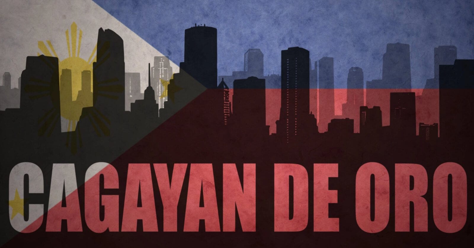 A stylized image of a city skyline with silhouettes of tall buildings. The background features the Philippine flag, blending into the skyline with its blue, red, white, and yellow colors and details. "CAGAYAN DE ORO," renowned for its tourist attractions, is prominently written in bold red letters across the bottom.