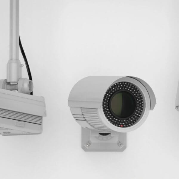 Three security cameras mounted on white walls. The leftmost camera has a rectangular housing; the one in the middle is cylindrical with an array of infrared LEDs around the lens; the rightmost camera is dome-shaped, enclosed in a transparent, spherical casing—an ideal setup by a top CCTV supplier in Metro Manila.
