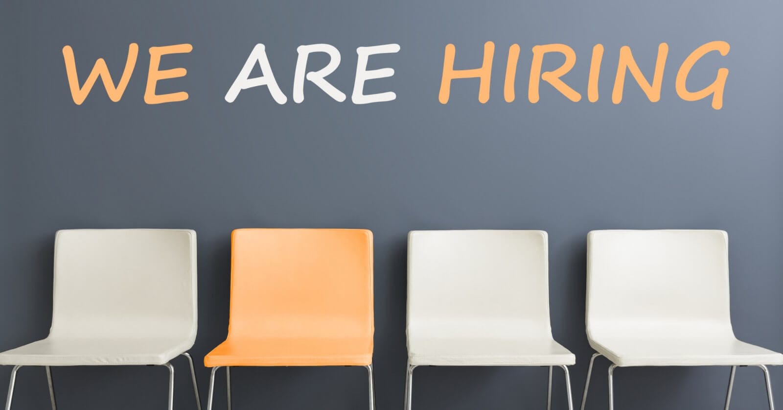 Four chairs are positioned in a row against a gray wall. The first, third, and fourth chairs are white, while the second chair is orange. Above them, the wall displays "WE ARE HIRING" in large white and orange letters—a familiar sight for those navigating job searches and employment agencies in Metro Manila.