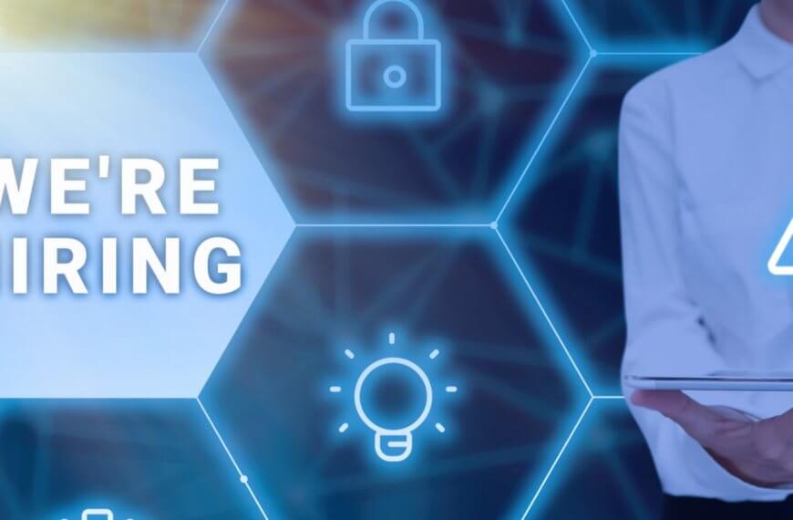 A person in a white shirt is holding a tablet and using a stylus, with a glowing network of hexagonal icons featuring a padlock, a warning sign, and a lightbulb. The text "WE'RE HIRING" is displayed prominently within one of the hexagons on the left side of the image, highlighting opportunities in Metro Manila for manpower agencies.