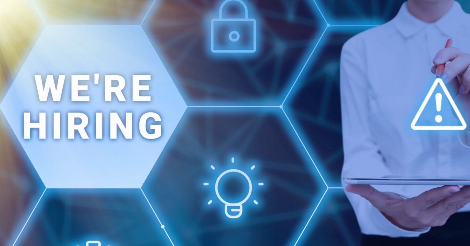 A person in a white shirt is holding a tablet and using a stylus, with a glowing network of hexagonal icons featuring a padlock, a warning sign, and a lightbulb. The text "WE'RE HIRING" is displayed prominently within one of the hexagons on the left side of the image, highlighting opportunities in Metro Manila for manpower agencies.