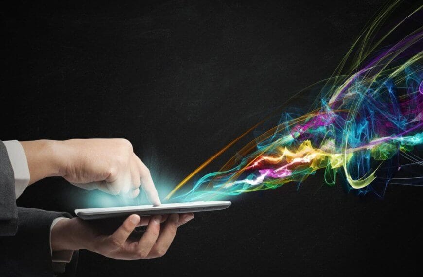 A person in a suit uses a tablet, with colorful, swirling light trails emanating from the screen against a dark background. This vibrant display of blues, greens, yellows, pinks, and purples resembles the dynamic pulse of IT companies in Metro Manila.