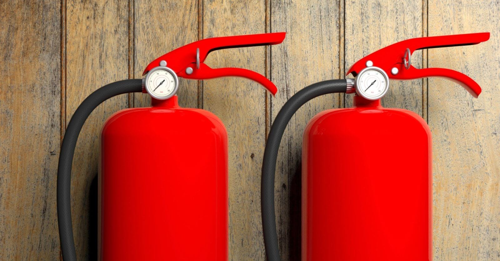 Two bright red fire extinguishers with black hoses and pressure gauges are mounted against a rustic wooden wall in Manila. The sleek, vibrant red of the extinguishers contrasts with the natural wood texture, while suppliers ensure timely fire extinguisher refills to maintain safety standards.