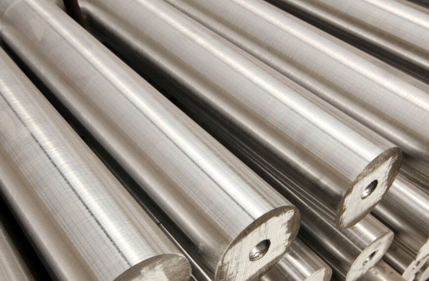 Close-up of several smooth, cylindrical metal rods stacked in parallel rows. Sourced from the best steel suppliers, these rods have a shiny, reflective surface and consistent diameter. Each rod has a small central hole at one end, adding a pattern to the otherwise uniform texture.