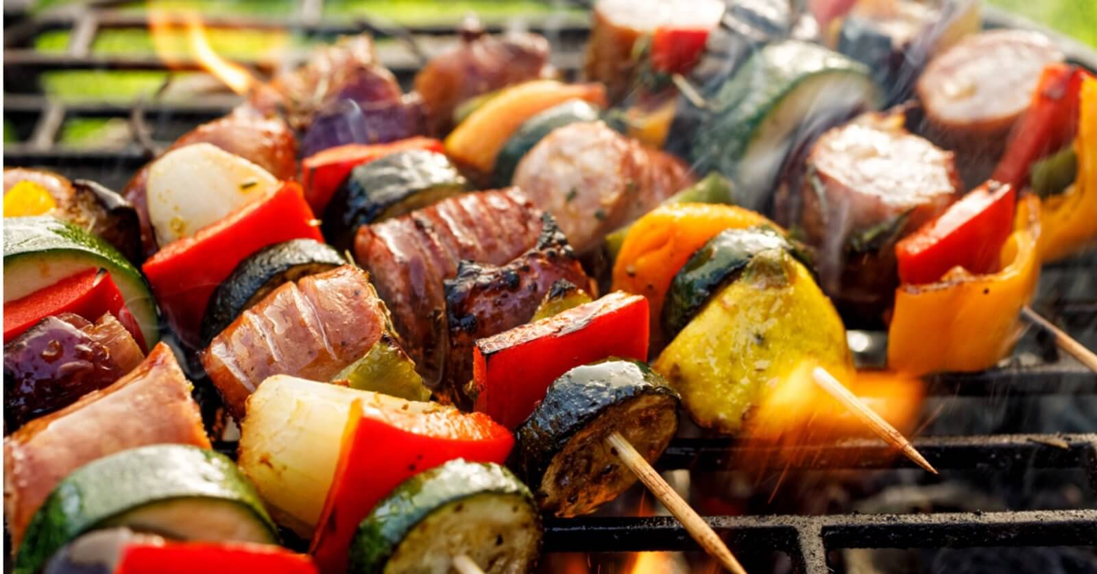 Grilled skewers with zucchini, bell peppers, onions, and meat sizzle over open flames, reminiscent of a vibrant evening in Iligan City.
