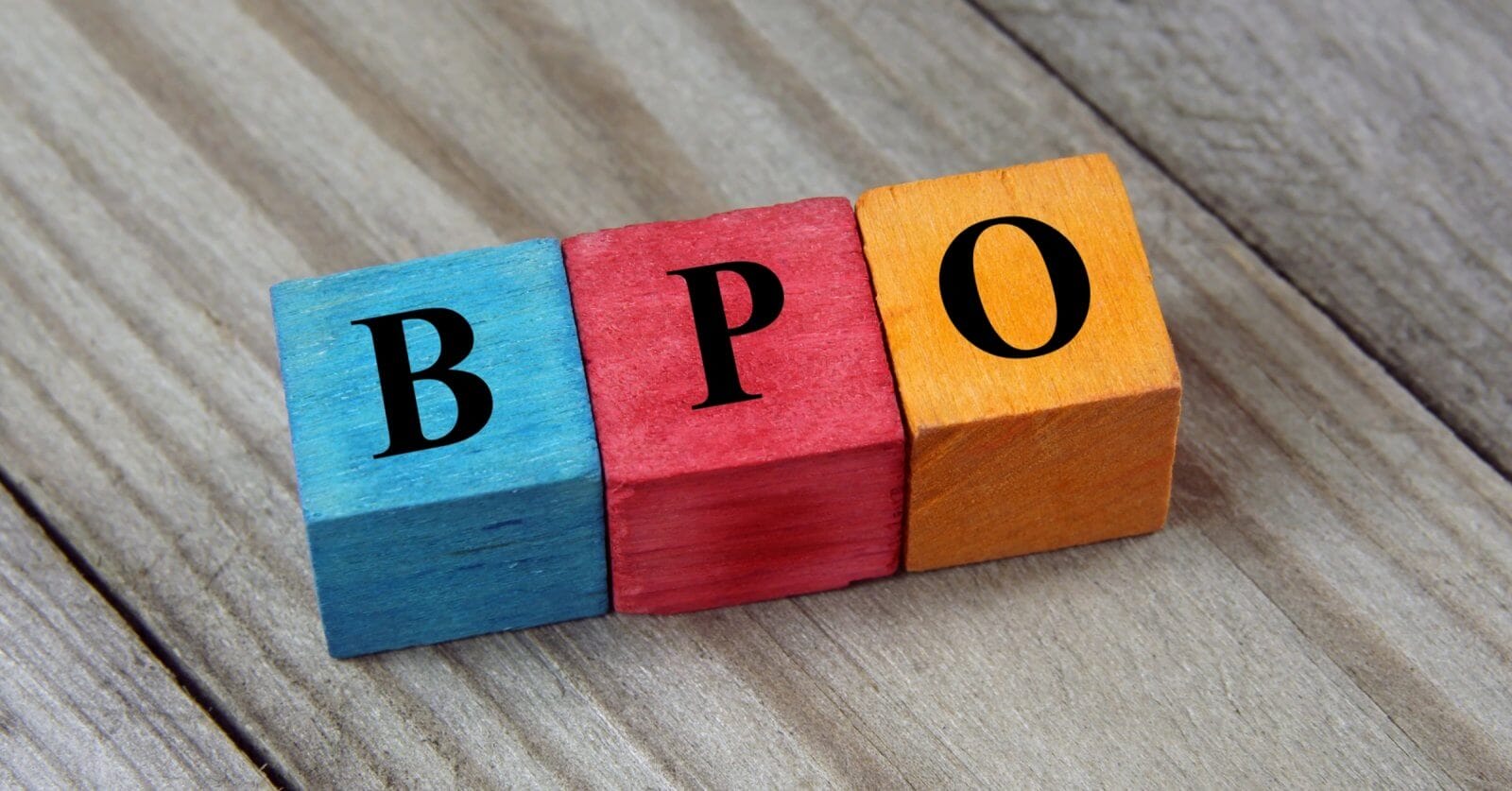 Colorful wooden blocks on a wood surface spell BPO in bold black letters, symbolizing the dynamic career growth opportunities offered by BPO companies in Makati City.