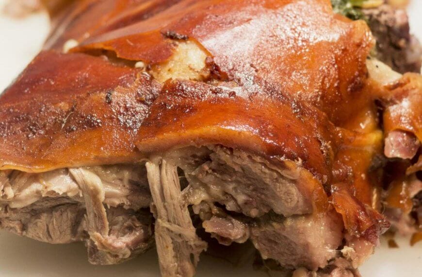 Close-up of crispy roast pork with golden skin and tender meat on a white plate, reminiscent of the flavors celebrated in Meycauayan's renowned restaurants.