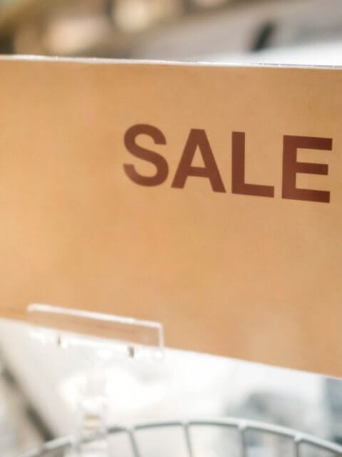 In a bustling Metro Manila outlet store, a vibrant sign reads SULIT DEAL while blurred shelves loaded with treasures sit invitingly in the background.