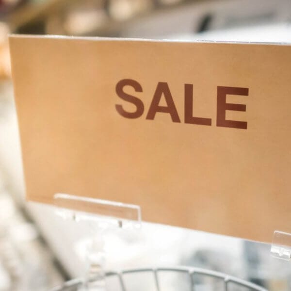 In a bustling Metro Manila outlet store, a vibrant sign reads SULIT DEAL while blurred shelves loaded with treasures sit invitingly in the background.